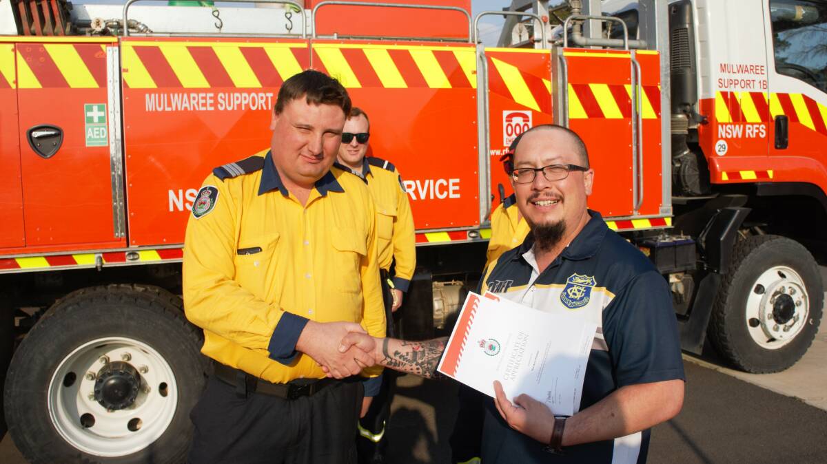Goulburn Mulwaree Support Brigade Captain Rodney Thistleton accepts a donation from The Rich Pitcher's Thady O'Connor. Photo: Ashley Pearce