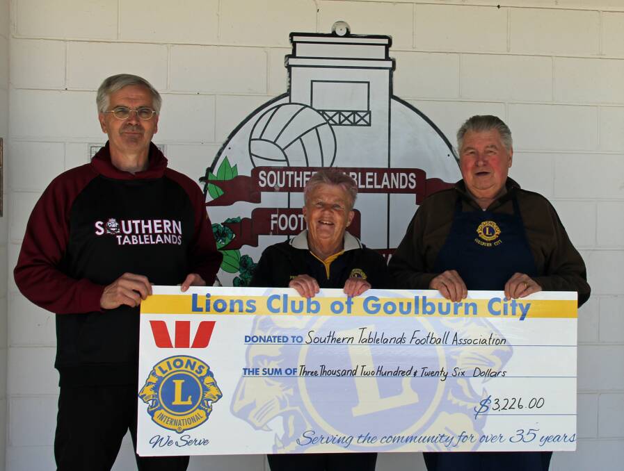 Donation: Tablelands Football Association President Robert Scott receiving the cheque from Prue Rickard and Lee Koll. Photo: supplied. 