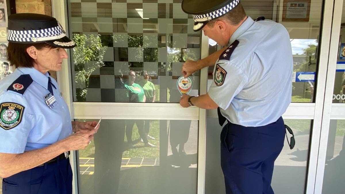 Officer in Charge, Inspector Matt Hilton places the sticker on the door at The Goulburn Police Station, reassuring the LGBTQIA community that they will be safe there.