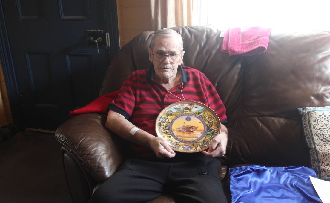 Wendell Howe with the commemorative plate marking the 55th anniversary of the HMAS Sydney. Photo: Burney Wong. 