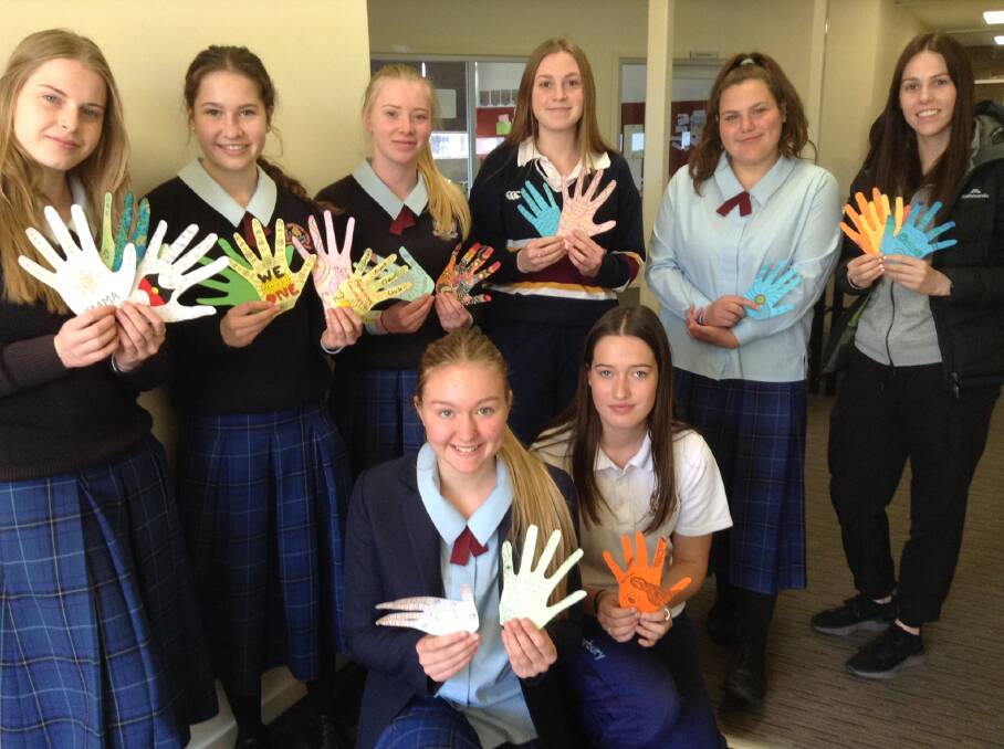 Celebrating culture: Year 9 and 10 Trinity Catholic College Students with their welcome hands. Photo: supplied.