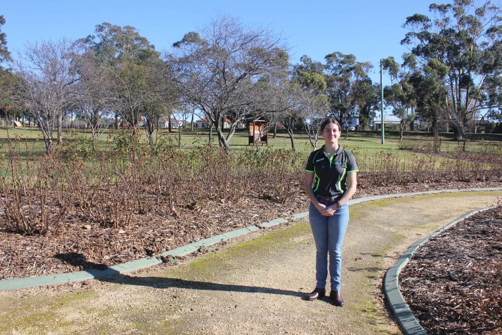 Goulburn Mulwaree Youth Council mayor Charlotte Hargan standing in the rose garden. The mindfulness garden is expected to be near the seat in the background. 