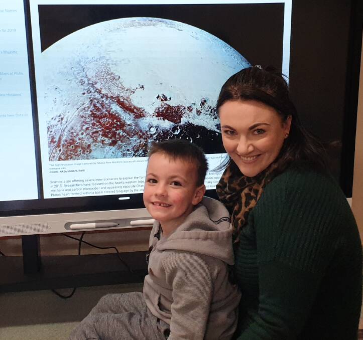 Chantelle Gurr and her son Tom Gurr using the smart board to research space on the NASA app.