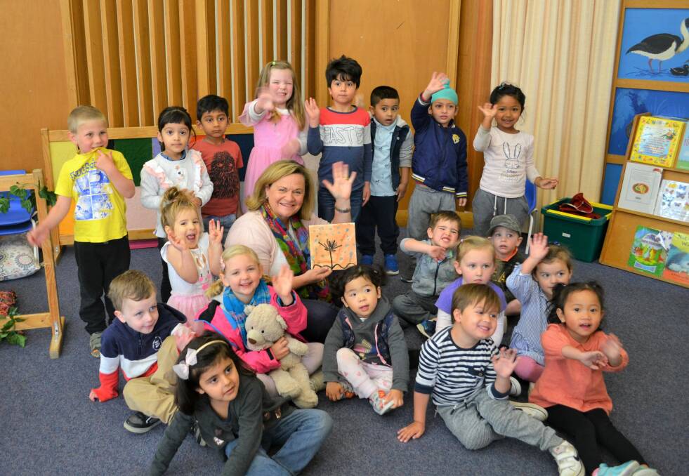 Member for Goulburn Wendy Tuckerman with children at Anglicares Orana Preschool in Goulburn. Wendy is holding a gift of art made and presented by the children, titled Rain Tree. Photo: Supplied