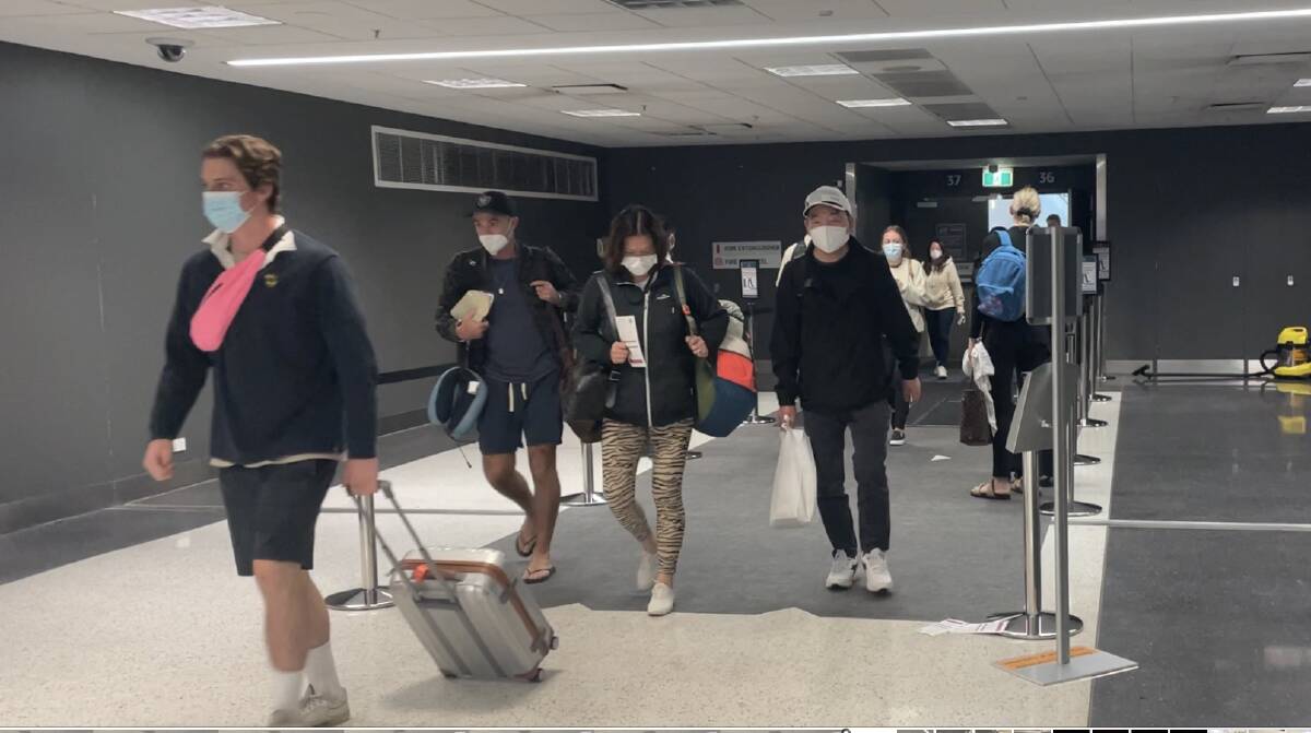 Passengers walking over special sanitiser mats at Sydney airport after arriving from Bali. Picture: Donna Page