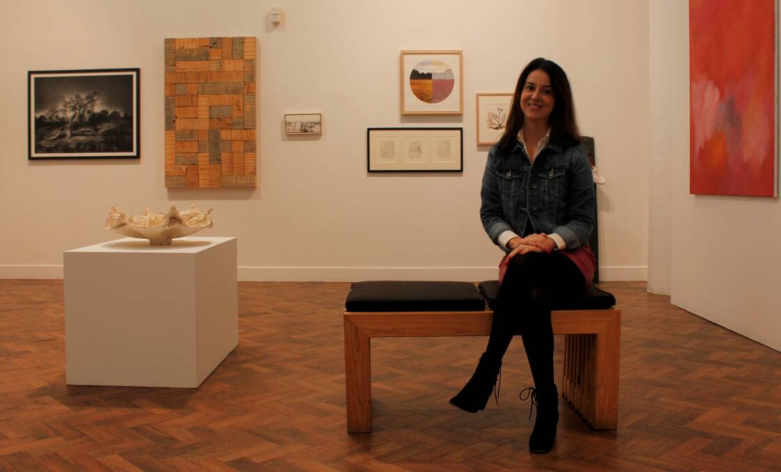 Artistic achievement: Goulburn Regional Arts Gallery director Gina Mobayed with works entered in the biennial Art Award, open to artists based within a 120 kilometre radius of Goulburn's city centre. Photo: Elspeth Kernebone.