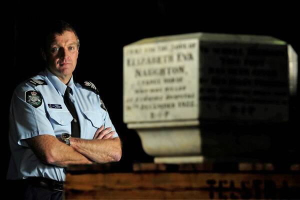 Sergeant Brett Cunningham is pictured above with the stone at Mitchell emergency response centre. Photo: STUART WALMSLEY
