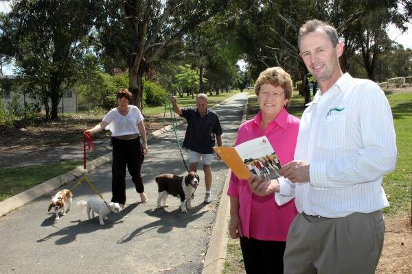 GET ACTIVE: Cherie Brown (with Stubby and Tinkerbell) and Barry Smith (with Lucy) walk through Victoria Park, as Goulburn Mulwaree Council’s Parks Administration Officer Jason Moroney goes over one of the Heart Foundation Neighbourhood Walkability Checklists with Lois Wood.
