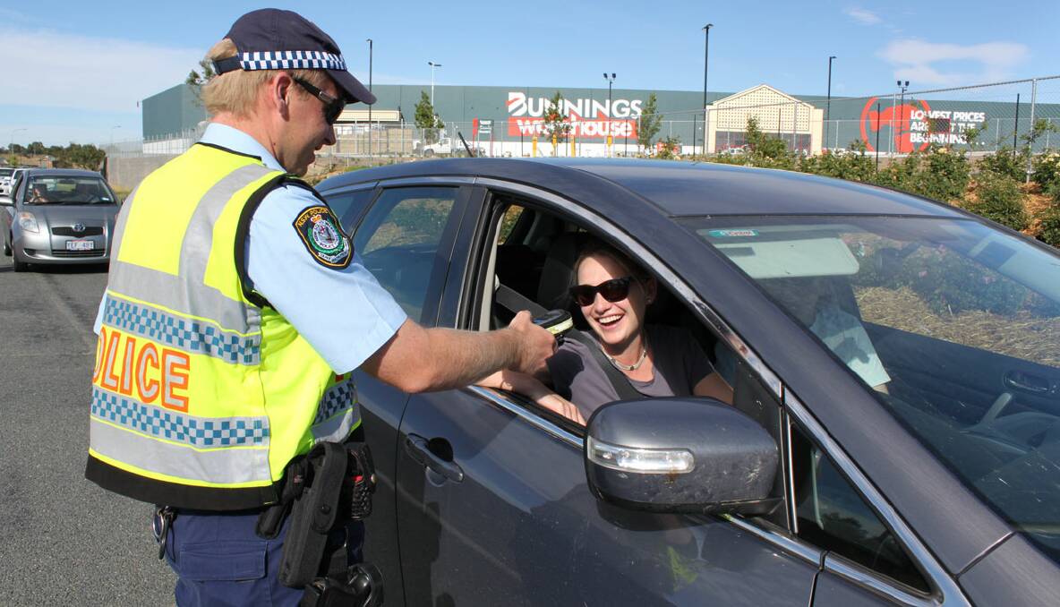 ON DUTY: Senior Constable Ben Smith breath tested motorist Virginia Croker at south Goulburn yesterday morning as part of Operation Safe Arrival. 