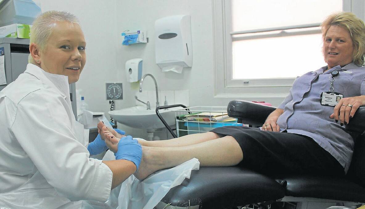 HAND AND FOOT: Local podiatrist Justine Kenny treats the feet of Goulburn Base Hospital receptionist Margaret Charles. 