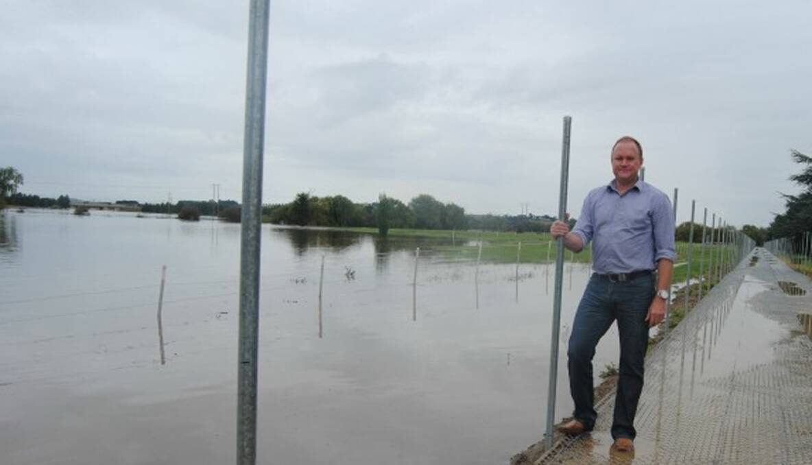 WE’LL DEFY THE FLOOD: Goulburn Greyhound Racing Club president, Patrick Day, surveys the water level from the training track.  