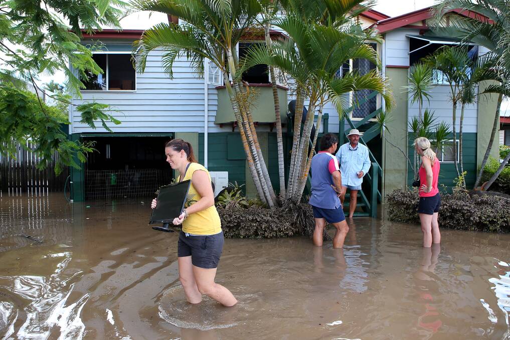Residents clean up debris in their street as parts of southern Queensland experiences record flooding in the wake of Tropical Cyclone Oswald on January 30, 2013 in Bundaberg, Australia. Photo by Chris Hyde/Getty Images