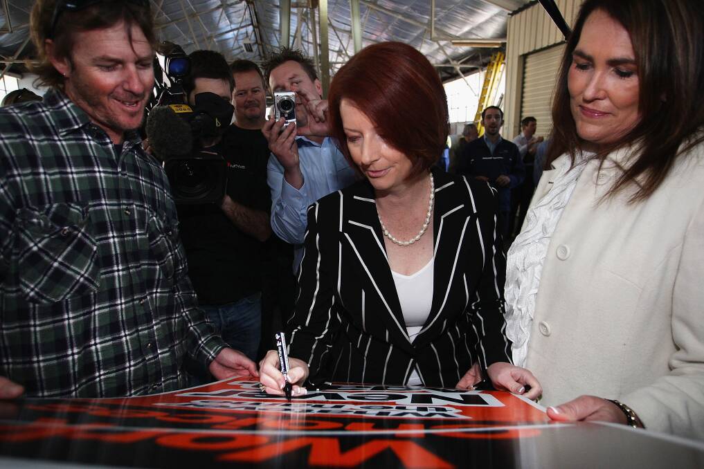 Prime Minister Julia Gillard autographs a 'no work choices sign' at the Engery Australia West Gosford Depot ahead of the Federal Election on August 20, 2010 in Gosford, NSW. Photo: Getty Images